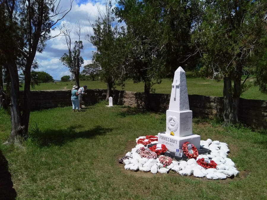 A white memorial to the fallen at Rorkes Drift stands in a small walled cemetary