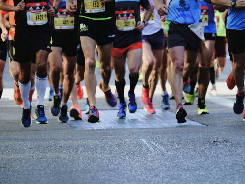 A group of runners dressed in run towards the camera.